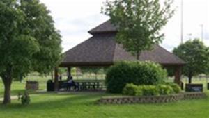 Park shelter with picnic tables in a wooded area